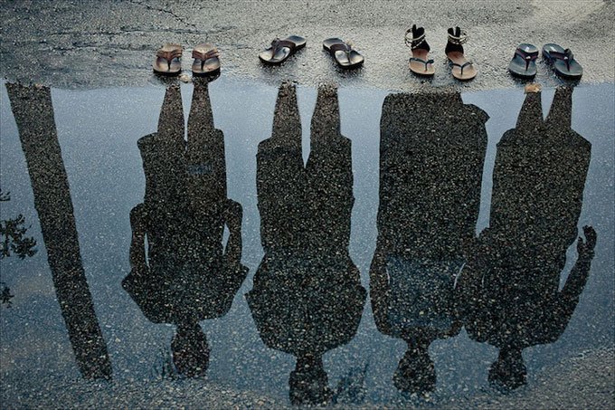 Shadow Family. Well-placed sandals, a puddle of water, the right amount of light and there you have it, a reflection of your family portrait. Source: FLIGRAFIE PHOTOGRAPHY